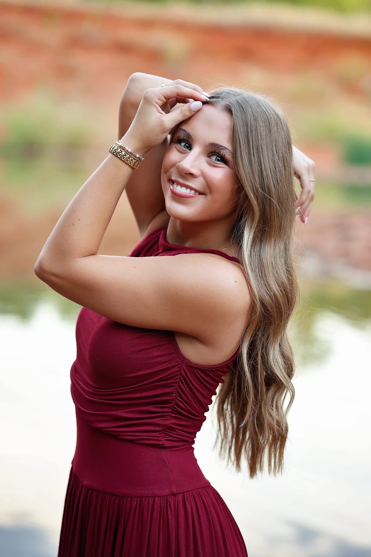 Violet Iver smiling, arms raised, in a burgundy dress